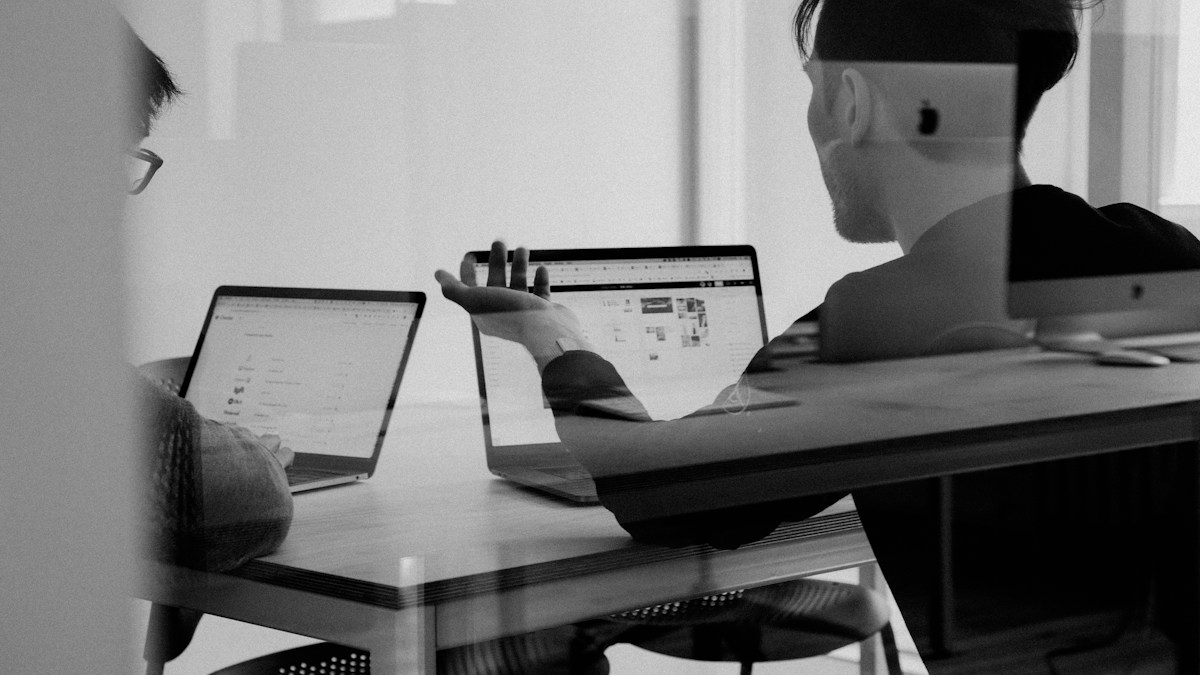 VP of HR, CIO, and Procurement Director analyzing Cloud LMS pricing, Total Cost of Ownership, and HRIS integration architecture in a modern boardroom
